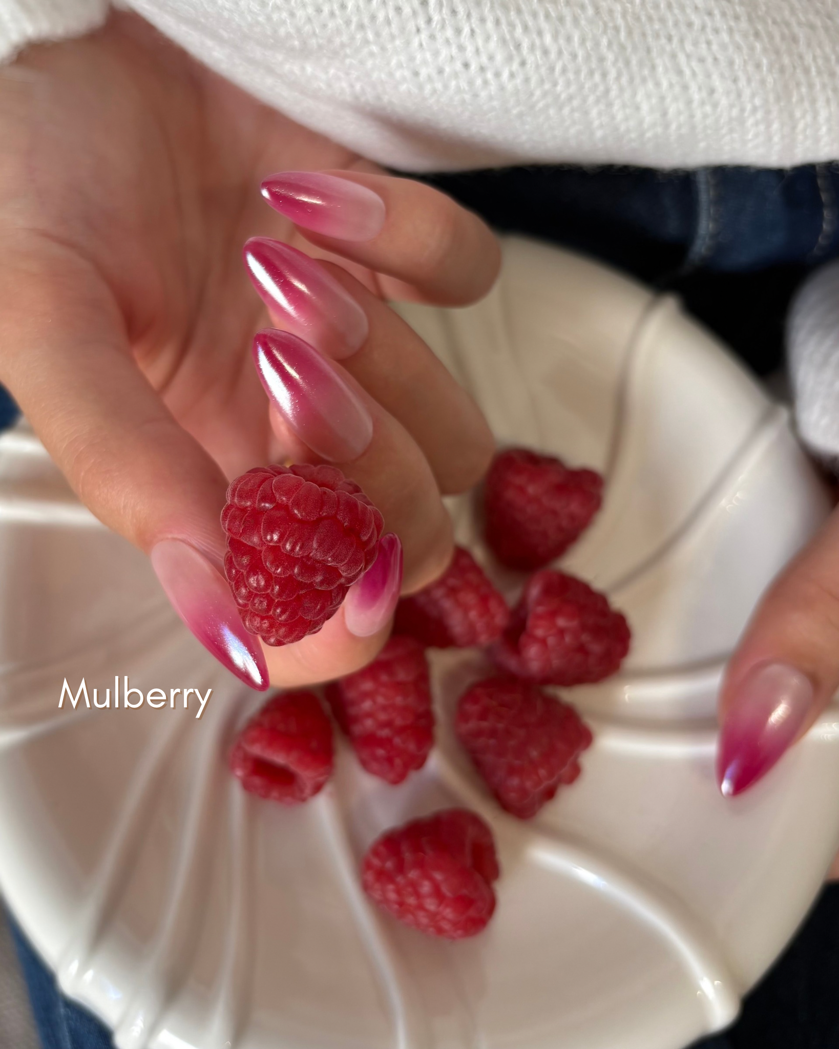 set de uñas press-on efecto glazed/aurora babyboomer en color  rosa muberry cogiendo una frambuesa con la mano