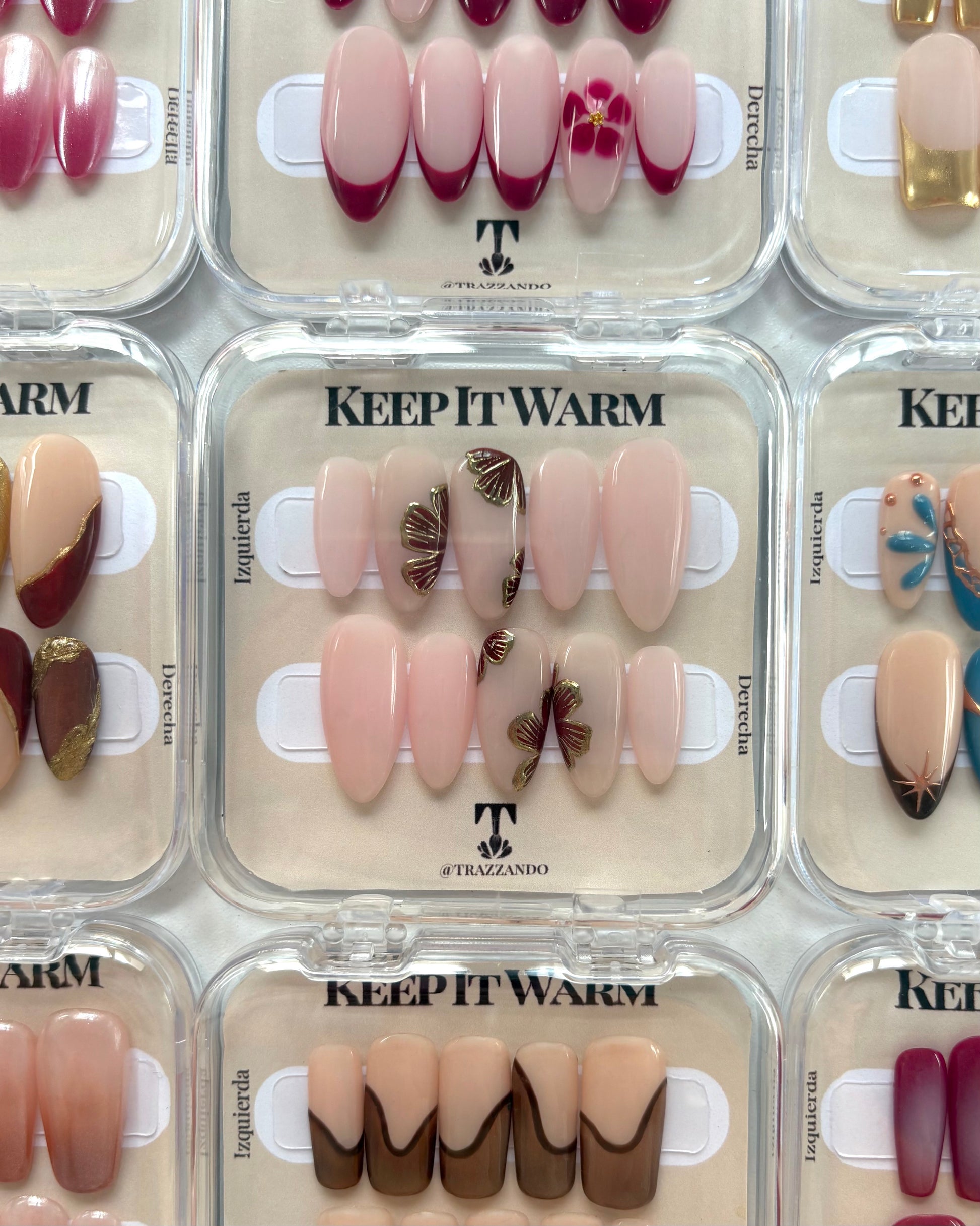 uñas press-on puestas en su caja original nudes con flores en color marrón y contorno dorado cromático trazzando