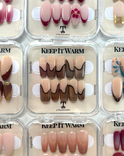 set de uñas press-on nude con francesa abstracta de color marrón con efecto ojo de gato y un línea delgada marrón que separa la francesa en su caja original colección keep it warm