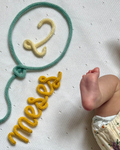 figura decorativa en lana globo 2 meses plano de cerca pie de bebe 