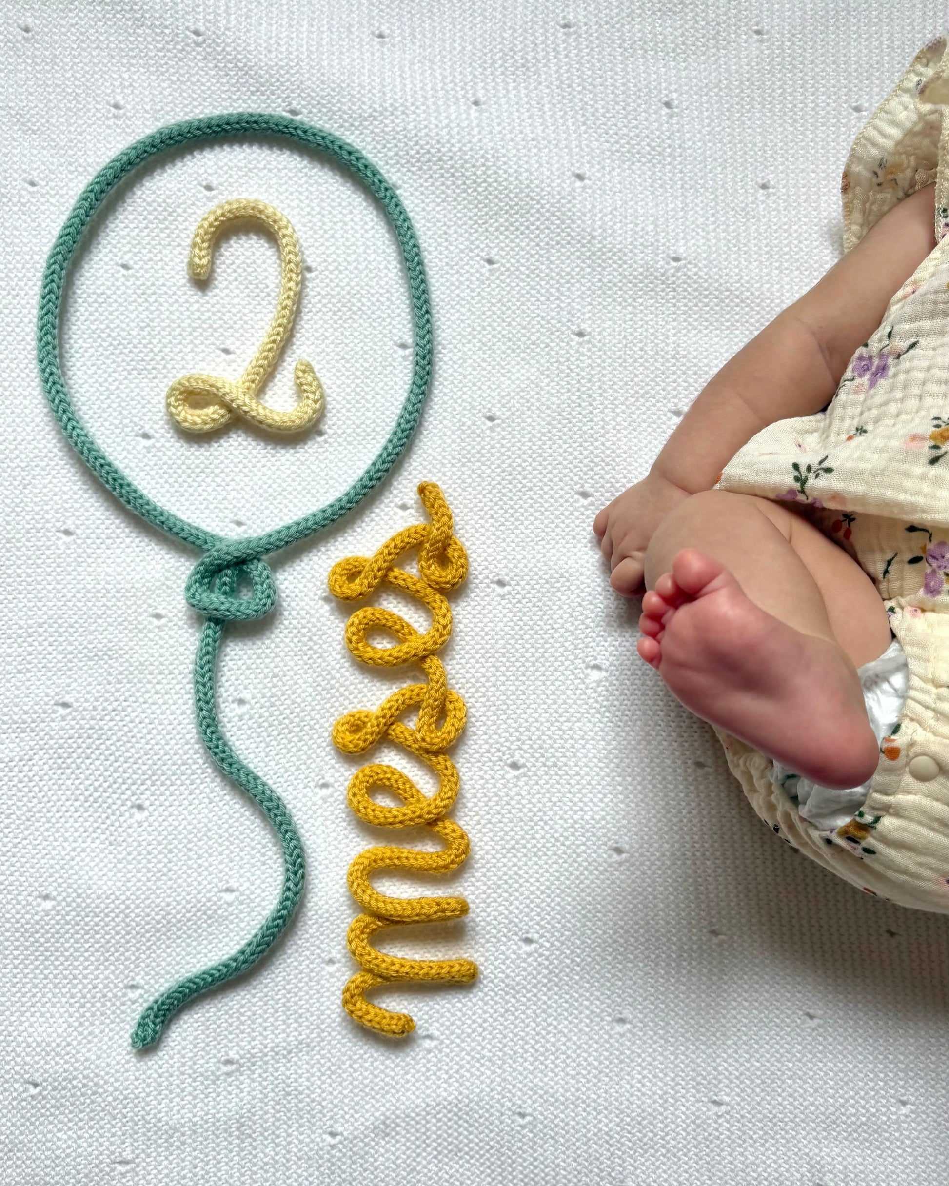 figura decorativa en lana globo 2 meses con bebe pierna