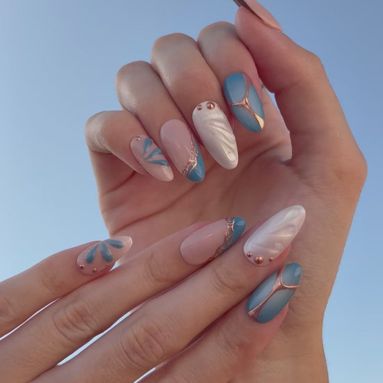 video de presentación set de uñas press-on azul con toques de cobre cromático, degradado con aerógrafo, blanco perlado con gotas de gel 3D, ojo de gato y estrella