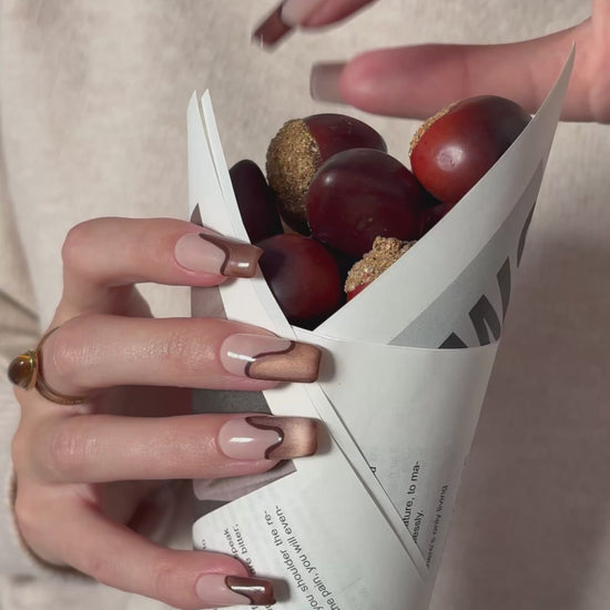 video de presentación set de uñas press-on nude con francesa abstracta de color marrón con efecto ojo de gato y un línea delgada marrón que separa la francesa